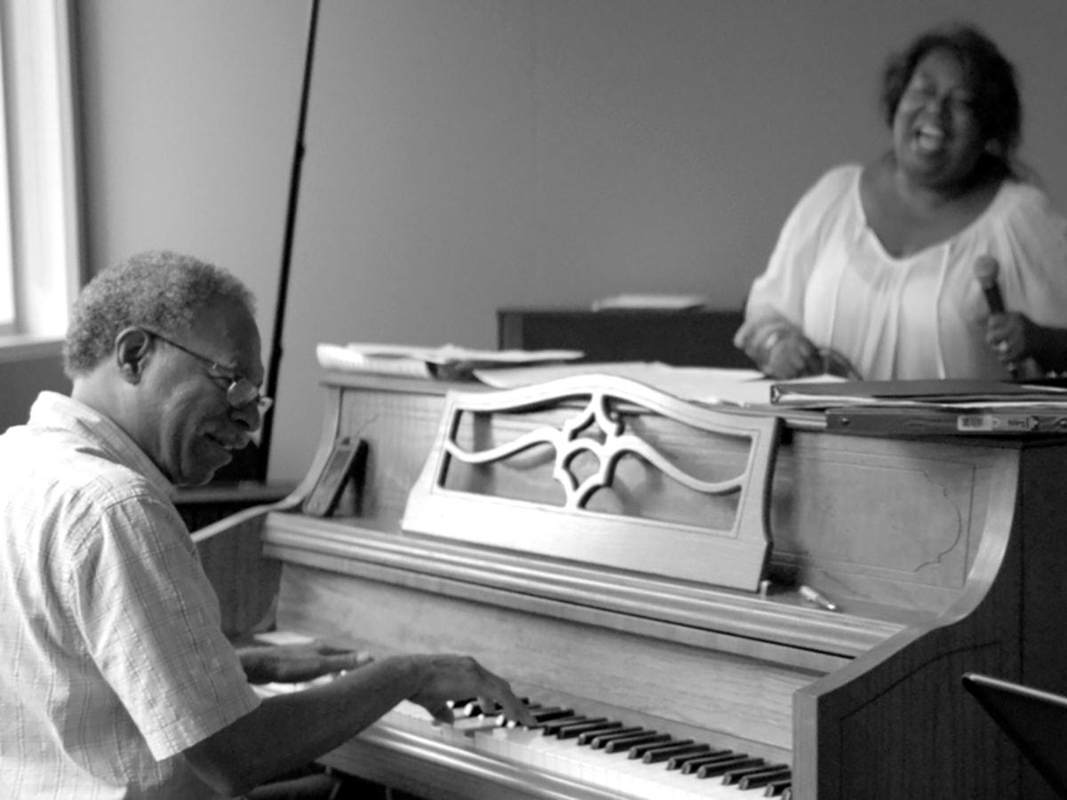 Man playing piano woman singing with microphone