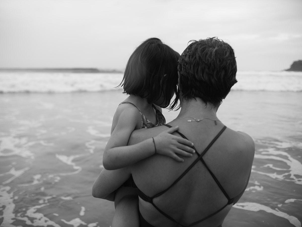 Woman holding child at beach
