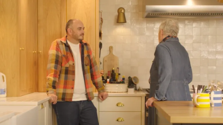 Jon (carer) and his mother Alyson (patient) stood together in a kitchen 