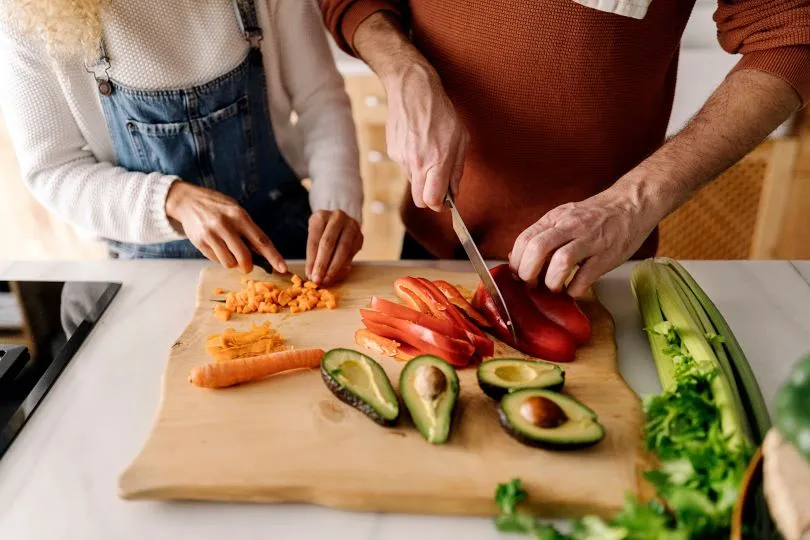 Person cutting vegetables on a wooden chopping board
