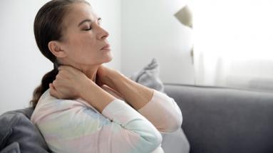 Woman relaxing on a sofa and stretching her neck