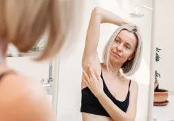 Lady self examining herself feeling for lumps