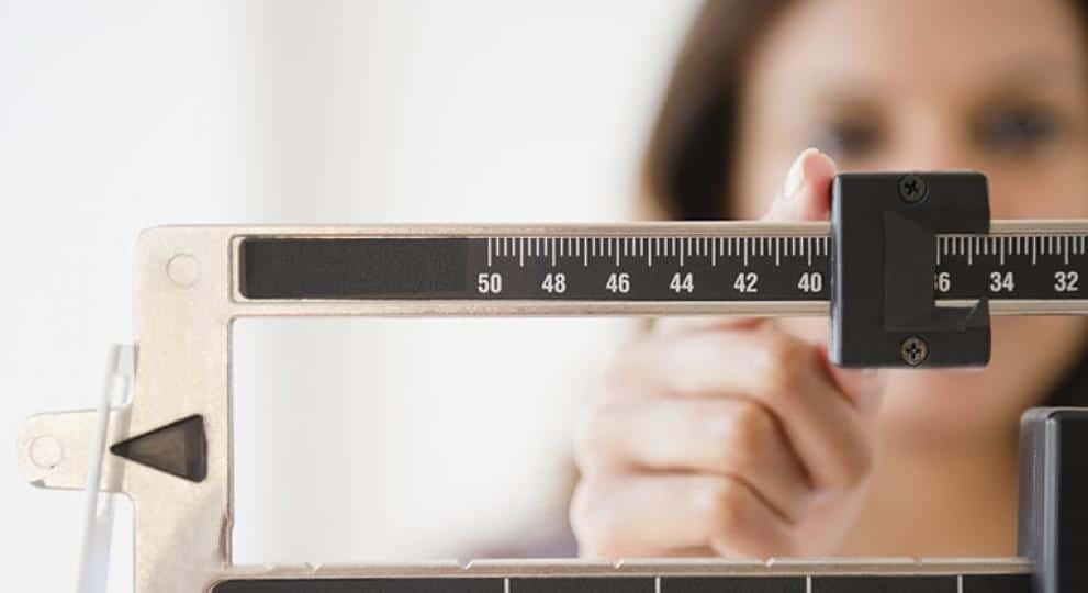 Woman measuring weight