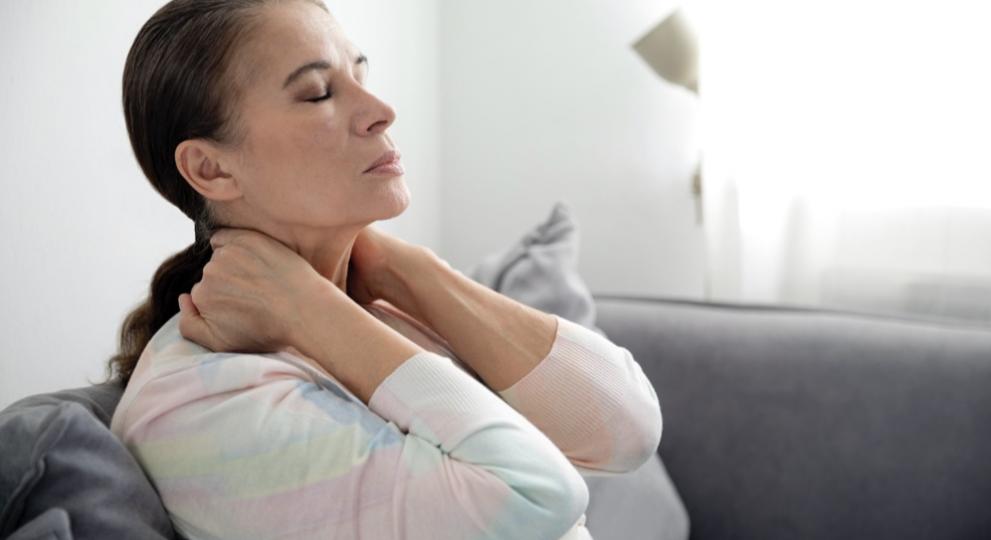Woman relaxing on a sofa and stretching her neck